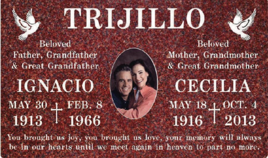 Red granite memorial for Ignacio and Cecilia Trijillo featuring their photo and white doves.